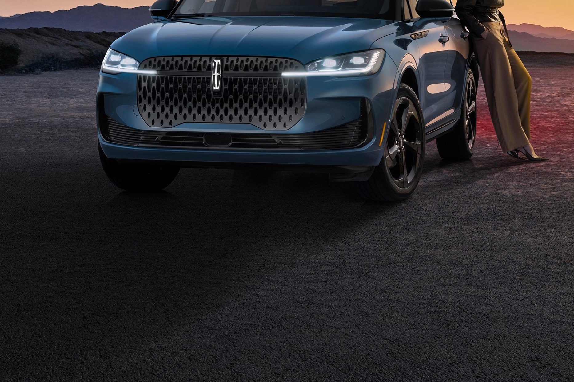 2027 Lincoln Corsair Hybrid front view of a blue SUV parked on a desert road at dusk
